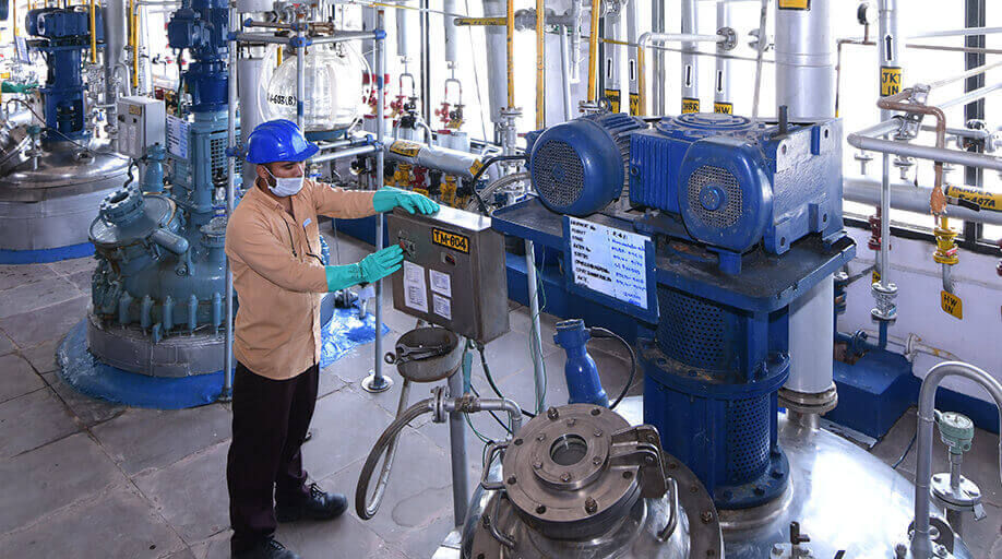 Morepen operator at a control panel among reactors on the API manufacturing floor